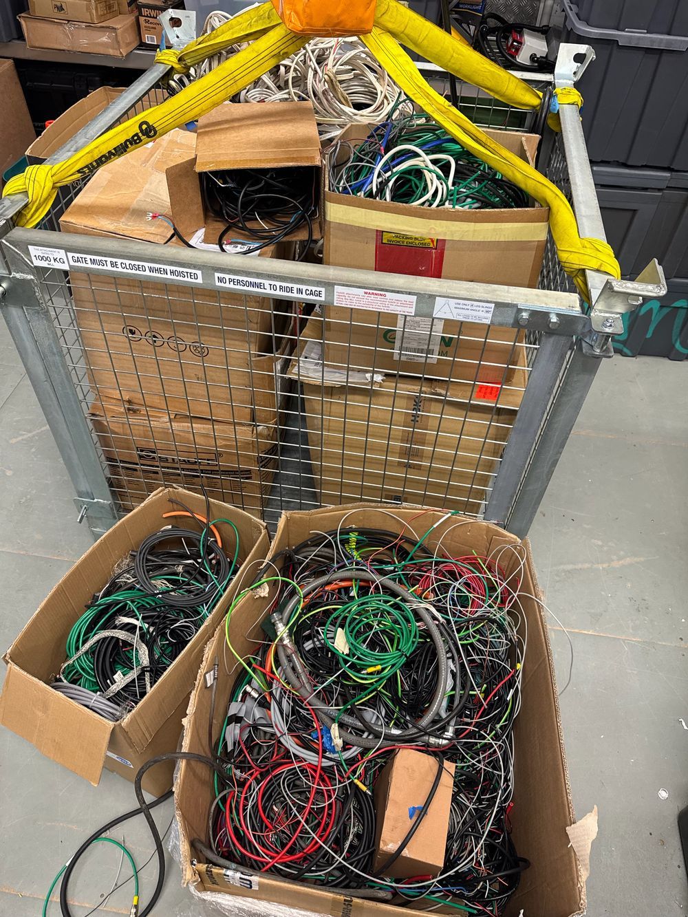 Cage and boxes full of scrap electrical cables collected from trades for recycling